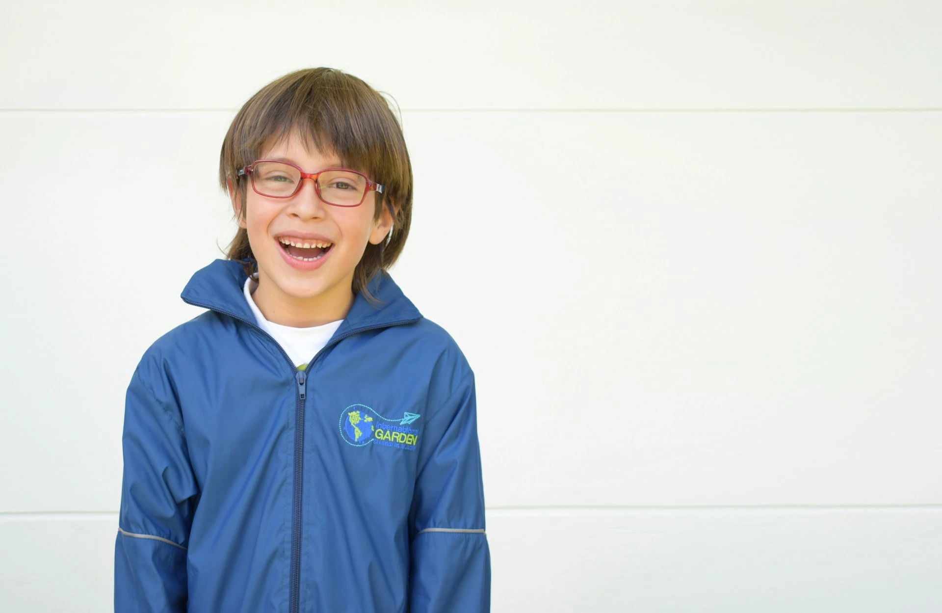 Lachende jongen met rode bril