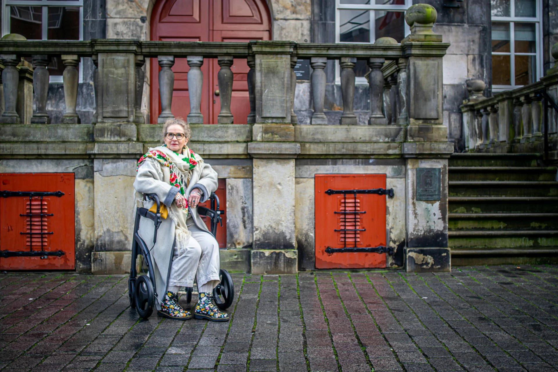 Vrouw met Parkinson zit op rollator